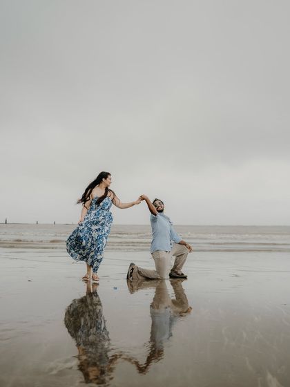 A classic proposal pose on the wet sand, with their reflection creating a beautiful symmetry. A perfect shot to celebrate the promise of forever.