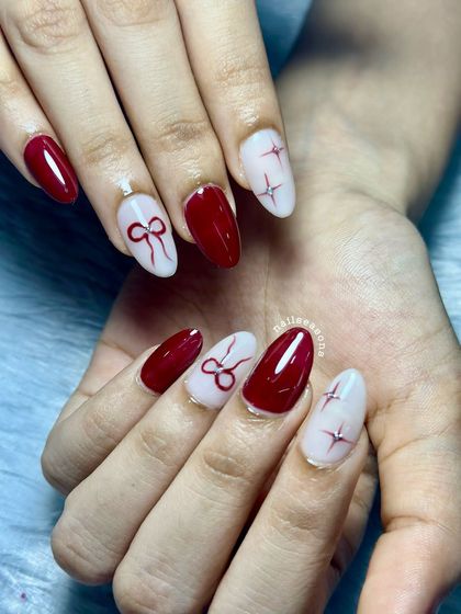 A chic and elegant design perfect for any celebration. This set features a wine-red polish with accent nails showcasing delicate, hand-painted bow and star art.