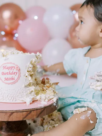 A close-up of the messy fun. This shot focuses on the tactile experience of the cake smash, a memory of textures and tastes for the baby.