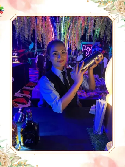 Our mixologist Aisha is captured in action, expertly shaking a cocktail at a beautifully lit event. This photo highlights the skill and confidence of our female bartenders.