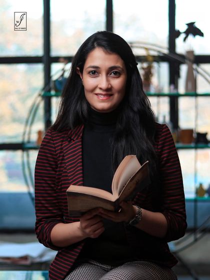 A variation of the headshot, incorporating a book as a prop to reflect the subject's personality or profession.