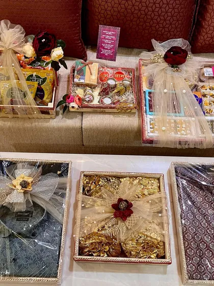 An overview of a complete trousseau packing project for a groom-to-be's family. This includes everything from packed shirts and traditional outfits to trays of sweets and dry fruits, all coordinated for a cohesive look.