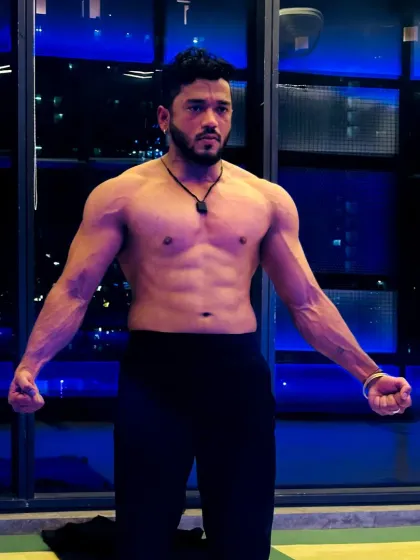 A powerful front pose showing a defined core and vascular arms. This is what peak conditioning looks like.