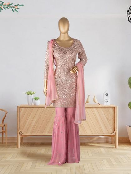 This sequined sharara set in a lovely pink shade is a perfect example of modern festive wear. The sparkle of the kurta combined with the flowing sharara pants makes it a standout piece for any wedding or party.