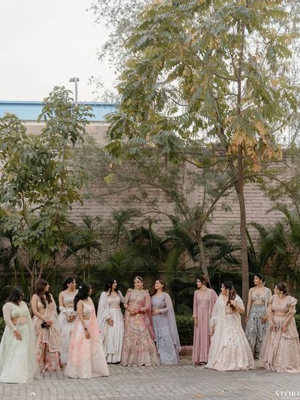 The bride, Riya, surrounded by her bridesmaids, sharing a moment of friendship and celebration.