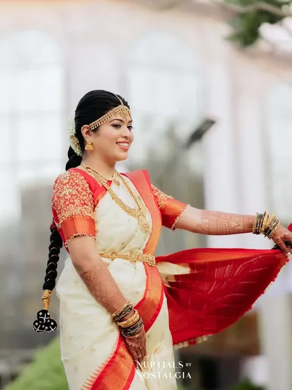 A full-length view of the bride's look, showing the beautiful drape of her saree and her traditional braided hairstyle. I offer professional saree draping as part of my bridal package.