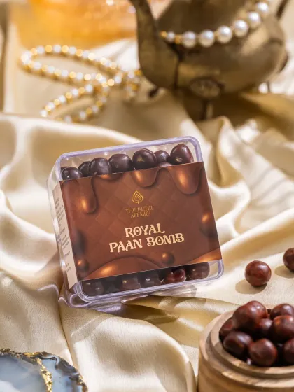 A box of Royal Paan Bombs, styled with soft, silky fabric and pearls to evoke a sense of indulgence.