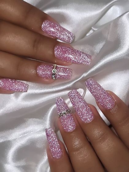 A full view of the sparkling pink party nails. The added rhinestone rings on the accent nails give them an extra touch of luxury.