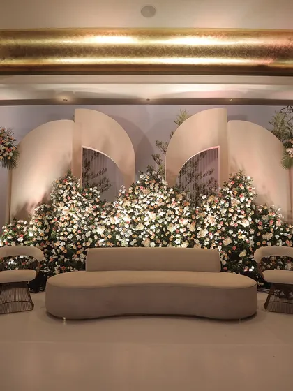 A full view of the artistic stage with its custom seating. The curved sofa and unique chairs complement the sculptural backdrop, creating a cohesive and high-fashion look for a modern event.