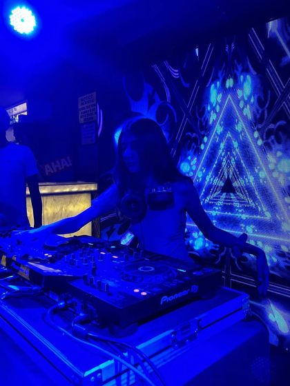 Striking a pose during my set at QB Lounge Bar in Dehradun. The blue lighting and triangular patterns created a futuristic vibe.
