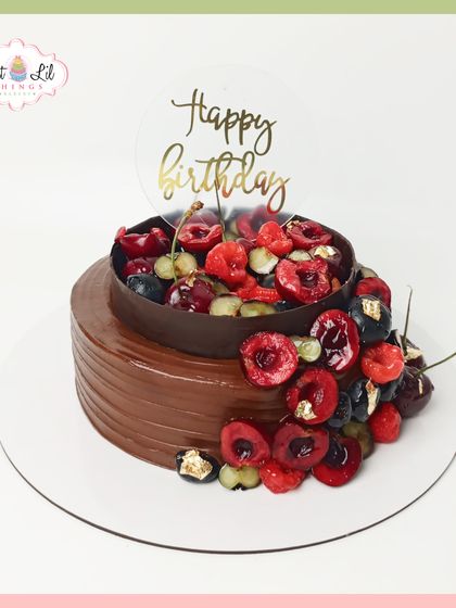 An indulgent chocolate cake overflowing with fresh berries. This design combines rich chocolate with a cascade of fresh cherries and raspberries, finished with a touch of edible gold leaf for elegance.