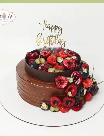 An indulgent chocolate cake overflowing with fresh berries. This design combines rich chocolate with a cascade of fresh cherries and raspberries, finished with a touch of edible gold leaf for elegance.