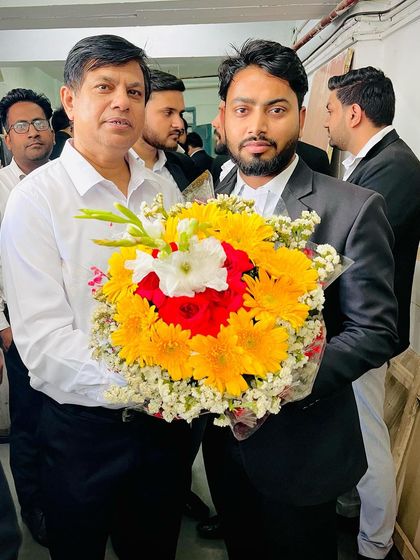 Wishing a senior colleague a happy birthday with a large bouquet of flowers.