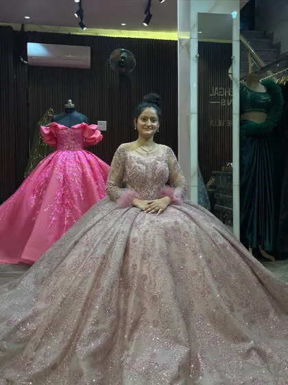 A seated portrait in our dusty pink ball gown, showing how the voluminous skirt creates a beautiful frame. In the background, our hot pink ruffled gown adds a pop of color, highlighting the variety in our studio.