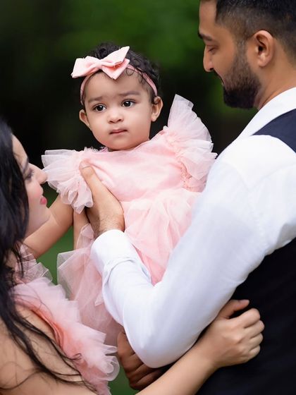 A close-up of a family sharing a moment with their young daughter. The focus is on their loving interaction and connection.