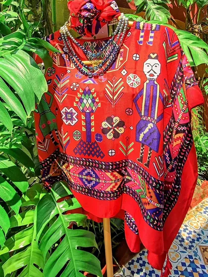 This vibrant red kaftan top features a unique folk-art print and comes with a matching bandana. It’s a fun, free-size piece that brings a splash of colour and personality to your wardrobe.