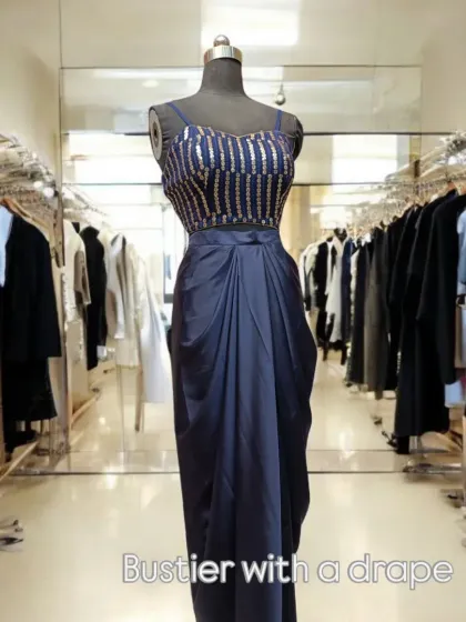 This ensemble pairs a sophisticated sequined bustier with a modern drape skirt. It's the ultimate fusion of contemporary style and trendsetting design, created for effortless elegance.