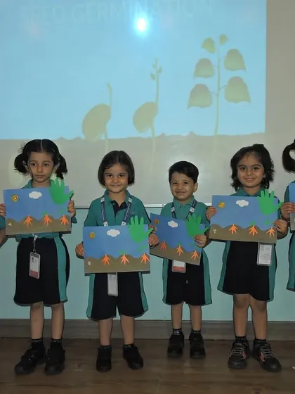 A group of students presents their germination-themed artwork. We provide many opportunities for children to proudly showcase their work and build confidence.