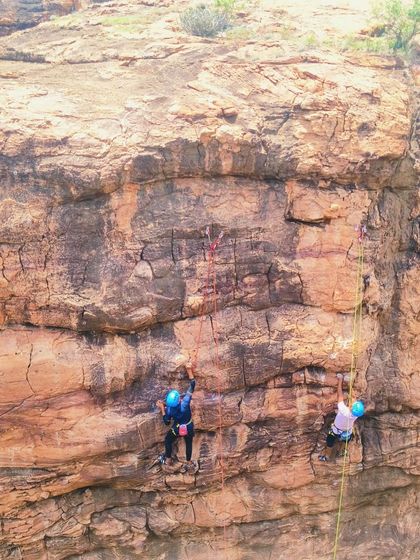 Two climbers scale a vertical wall, demonstrating the skills learned in our advanced course.