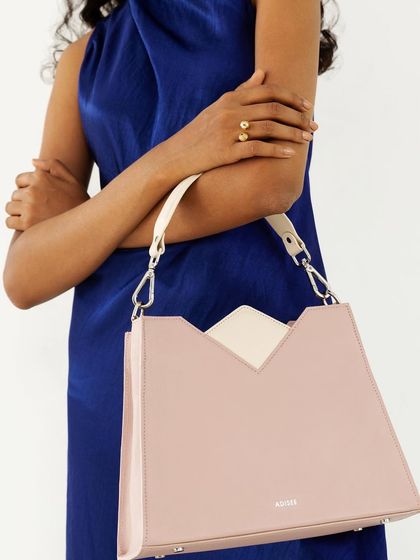 This shot showcases the versatility of the handbag by showing it worn with a shoulder strap. The styling is elegant and modern.