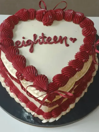 A bold and beautiful heart-shaped cake for an eighteenth birthday. The deep red and white buttercream piping creates a striking and romantic look.