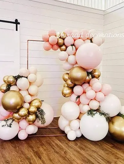 This modern and minimalist balloon sculpture is perfect for an outdoor event. The arrangement uses pastel pink, white, and gold balloons on a simple copper frame, creating a piece of art.