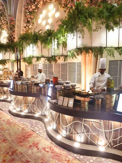 Our live cooking stations are designed to be beautiful. This curved counter with integrated lighting and hanging greenery is as much a part of the decor as it is a food station.
