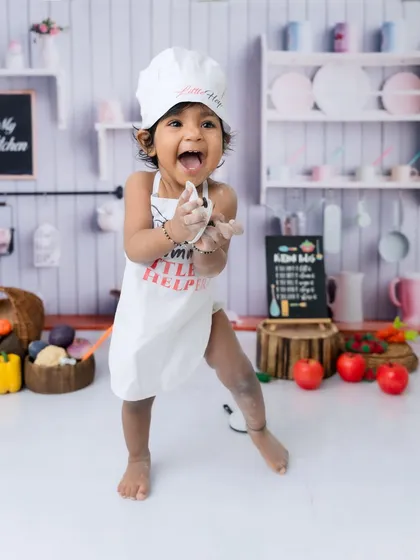 A burst of pure joy! This little chef is dancing with happiness in her mini kitchen setup.