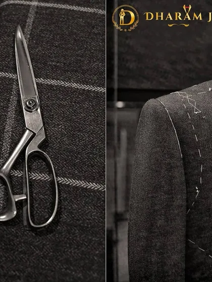 A glimpse into the tailoring process. The tailor's scissors and the half-finished jacket with visible basting stitches show the hands-on work that goes into every bespoke suit.