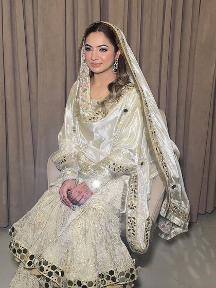 The full look for Maanvi's Roka. The white and gold outfit is perfectly complemented by the soft, luminous makeup.