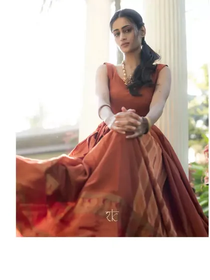 A rust orange cotton silk long dress that exudes warmth and elegance. The traditional silk border adds a touch of heritage to the simple, graceful silhouette.