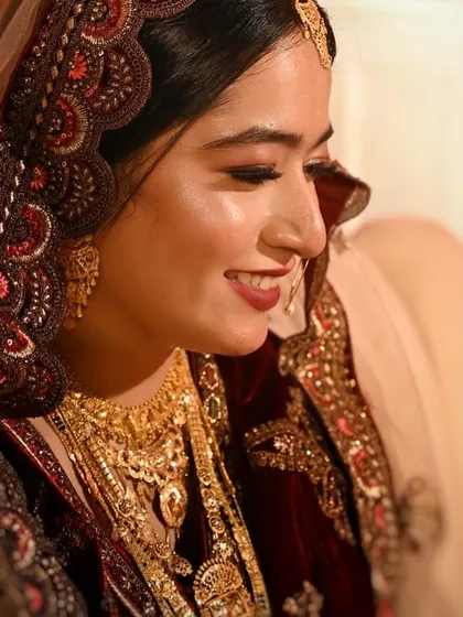 A beautiful profile shot of another Nikah bride, highlighting the glowing skin, defined eyes, and a lovely red lip.