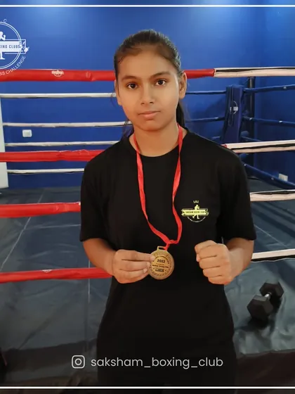 Hard work pays off. Here is one of my dedicated female boxers proudly displaying her medal, a testament to her commitment and the quality of our training.