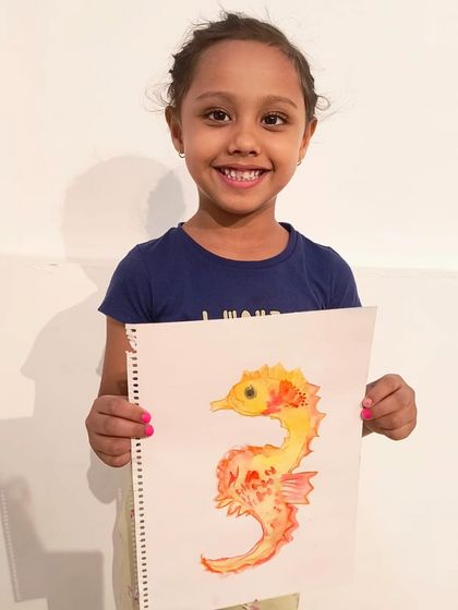 A big smile from this young artist, who is thrilled with her vibrant and colorful watercolor seahorse.