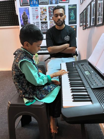 A young student receives focused instruction during his keyboard lesson. This personalized attention helps correct posture and technique from the very beginning.