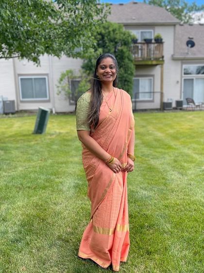 A client looking lovely and serene in a peach-colored saree from my collection.