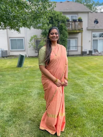 A client looking lovely and serene in a peach-colored saree from my collection.