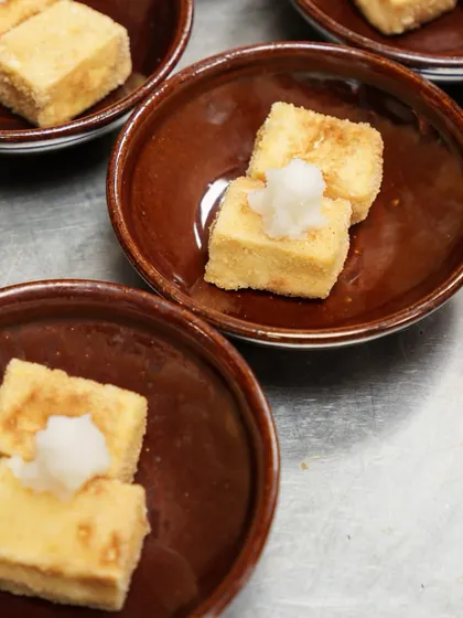 Several bowls of Agedashi Tofu, prepared for a catering order. It's a dish that we take great care in preparing, ensuring each piece is perfect.