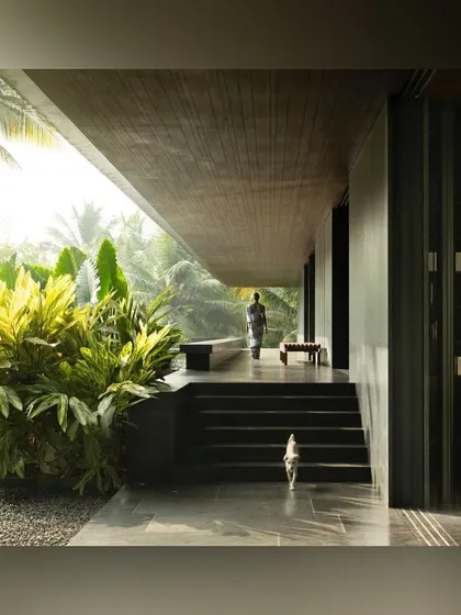 A covered walkway connects different parts of this Alibaug home, flanked by lush tropical foliage. The design ensures that even moving between rooms is an experience of being immersed in nature.