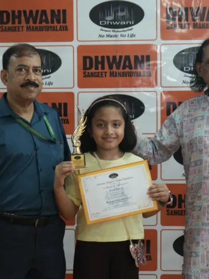 A senior guru presenting an award to a young student, passing on the legacy of art.