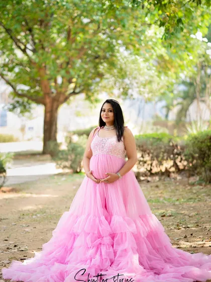 Like a fairytale princess in the park. This mom-to-be glows in a magnificent pink ruffled gown, creating a truly enchanting outdoor maternity portrait.