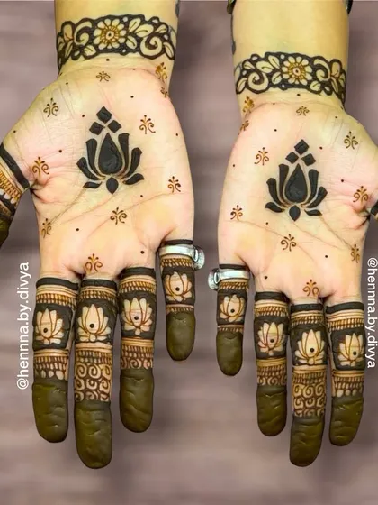 For a touch of modern elegance, I designed this minimal mehendi featuring a bold lotus motif on the palm and matching lotuses on each fingertip. It's a simple yet striking look, ideal for guests who prefer understated henna art.