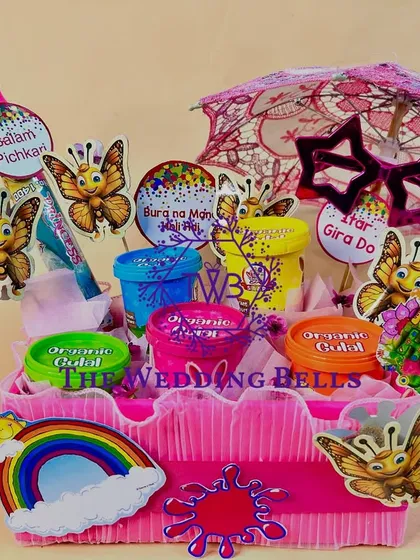 The complete "Summer's Here" Holi hamper, with a pichkari, a mini umbrella, and other festive accessories.