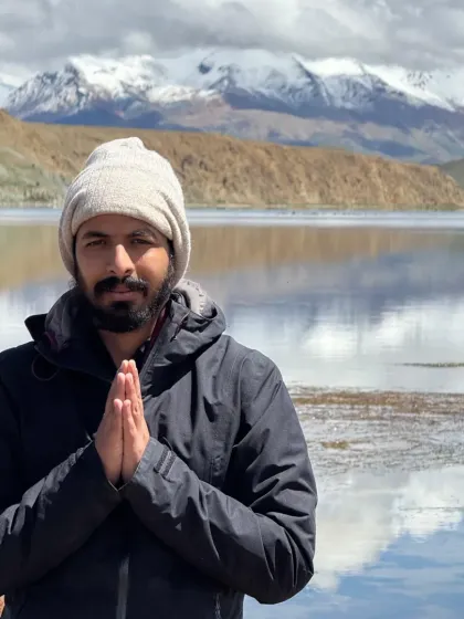 A moment of gratitude by the lake, with the reflection of the mountains on its calm surface. The beauty of this place is a manifestation of the divine.