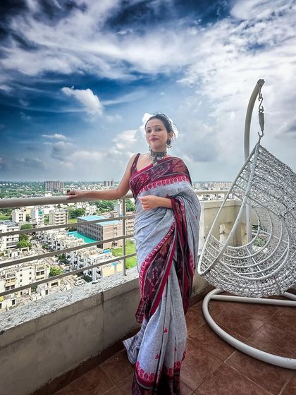 Another balcony shot, because this saree and this sky were a perfect match. The bun hairstyle keeps the look clean and lets the saree's intricate border shine.