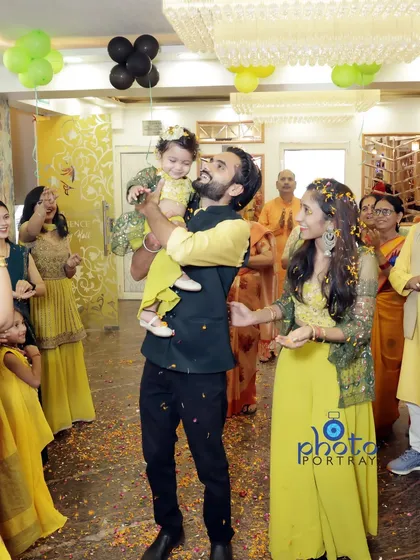 A candid shot of the celebration, with the father holding his daughter as guests shower them with flower petals.