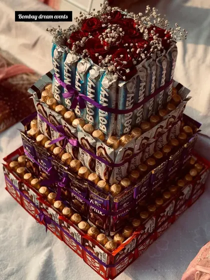 A grand, three-tiered chocolate tower made from a variety of popular chocolates and topped with fresh roses. We can customize the chocolates and size to your preference.