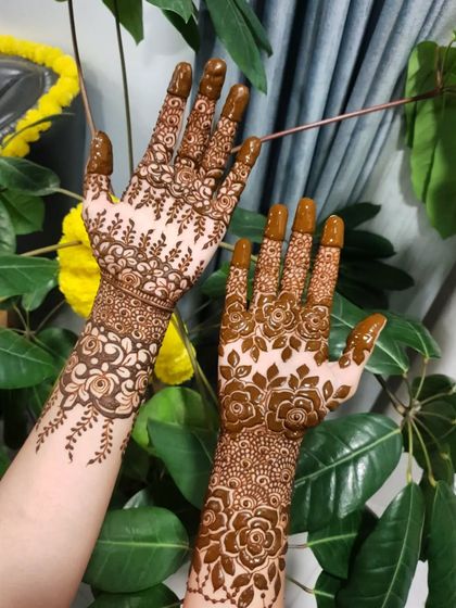 A full view of these complementary floral party henna designs.