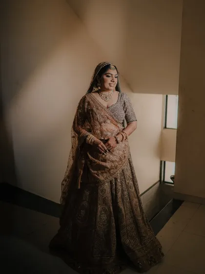 A solo portrait of the bride, Laxmi, captured in a quiet moment on a staircase, her expression thoughtful and serene.