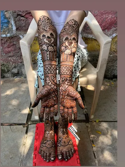 Here is a complete bridal mehndi look, with detailed, symmetrical designs covering the arms, hands, feet, and legs. I ensure the patterns flow beautifully for a stunning result from every angle, making you feel like a queen on your special day.